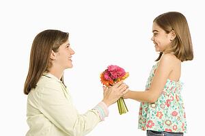 Girl giving mother bouquet of flowers