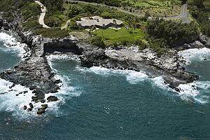 Rocky coastline on Maui, Hawaii with rooftop view of building and road