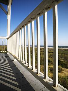 Wooden railing on porch overlooking beach at Bald Head Island, North Carolina