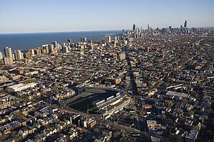 Aerial view of Wrigley Field with Chicago, Illinois skyline in background.