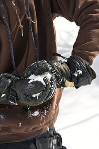 Gloved hands making snowball