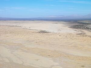 Aerial view of remote California desert with mountain range in background