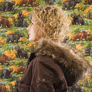 Profile of Caucasian young adult woman wearing coat with fur hood.