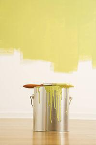 Still life of paintbrush on paint can with painted wall.