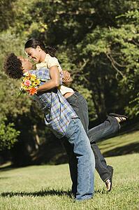 Couple smiling and embracing in park