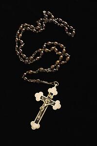 Christian rosary beads with crucifix on black background