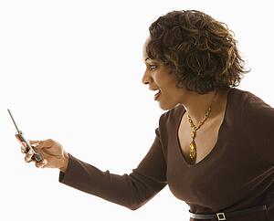 Side view of woman looking at cellphone with happy expression.