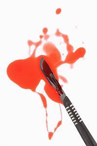 Medical scapel with fake blood around it.