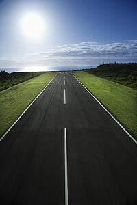 Airplane runway with Pacific ocean in background.
