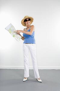 Full length portrait of Caucasian woman holding map and pointing to location.