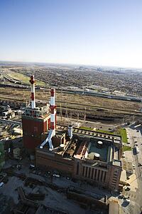 Aerial view of factory with smokestacks and city in distance