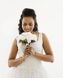Portrait of a mid-adult African-American bride holding bouquet.