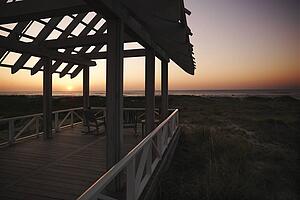 Gazebo at North Carolina coast with setting sun in background.