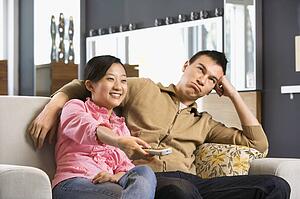 Couple sitting on couch watching TV