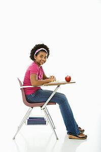 Girl sitting in school desk smiling 
