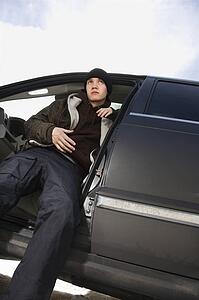 Male teenager sitting in SUV