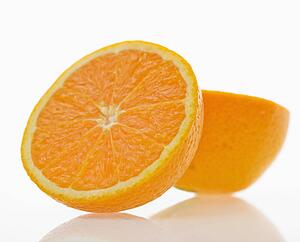 Still life of halved orange against white background.