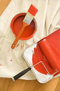 Painting supplies on drop cloth on wood floor