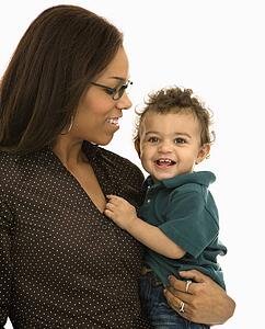 Mom holding toddler son with happy expression