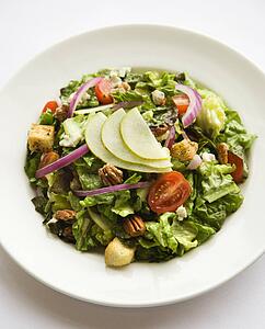 Prepared salad with walnuts and tomatoes.