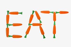 The word eat spelled out with carrots on white background.