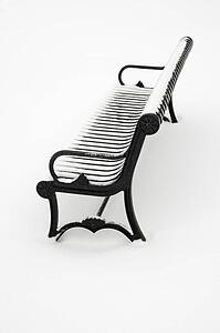 Black iron bench in snow.