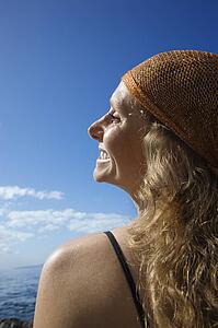 Woman with wavy hair and head scarf at coast