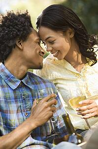 Affectionate couple drinking wine outdoors