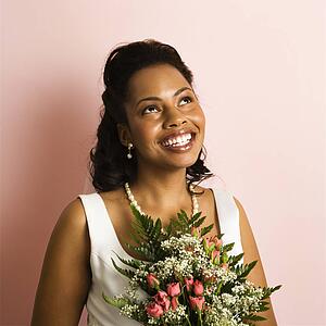 Portrait of a mid-adult African-American bride on pink background.