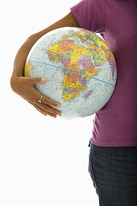 Arm and hips of woman holding globe