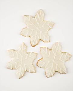Three snowflake sugar cookies with decorative icing.