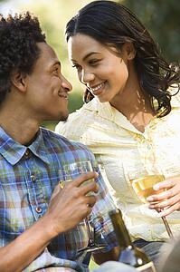 Couple having wine on romantic park picnic