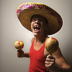 Portrait of a Mid-adult Caucasian male wearing sombrero holding maracas.