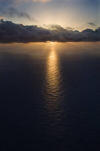 Sun setting over Pacific ocean with clouds