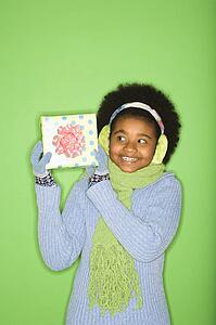 Girl in winter clothing holding wrapped package