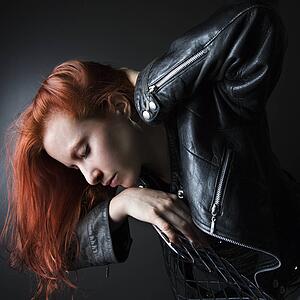 Woman wearing leather jacket hanging over back of chair