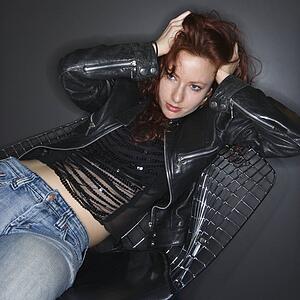 Portrait of pretty redhead young woman holding hands to head.