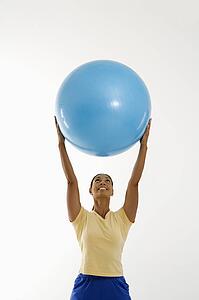 Woman standing and holding exercise ball