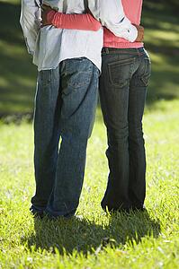 Low view of couple standing in park with arms around each other