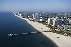 Aerial view of waterfront buildings and pier over ocean at Pompano Beach, Florida