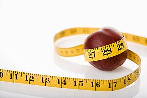 Measuring tape wrapped around nectarine.