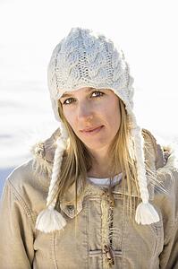 Young adult woman in winter attire looking at viewer.