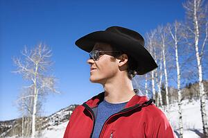 Cowboy wearing sunglasses and cowboy hat in winter.