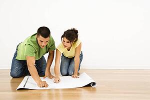 Attractive young adult couple looking at house plans.