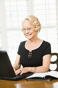 Senior woman using laptop in living room