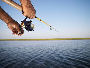 Holding fishing rod and reeling with the other hand