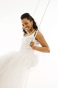 Mid-adult bride swinging with white background