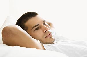 Man lying with hands behind head