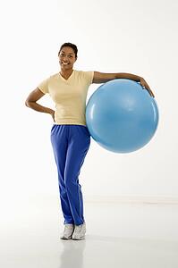 Woman standing with exercise ball 