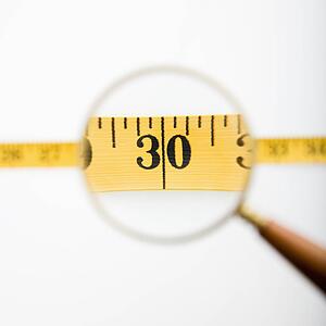 Magnifying glass held over measuring tape